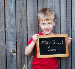 Young,boy,holding,blackboard,advertising,after,school,care