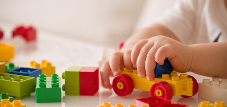 Close,up,of,child's,hands,playing,with,colorful,plastic,bricks
